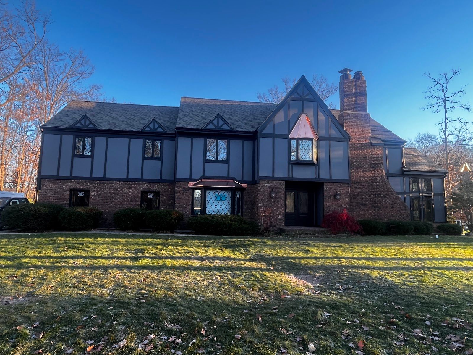 After - Tudor-style home in Schererville, IN with new siding panels, dark trim and copper accents